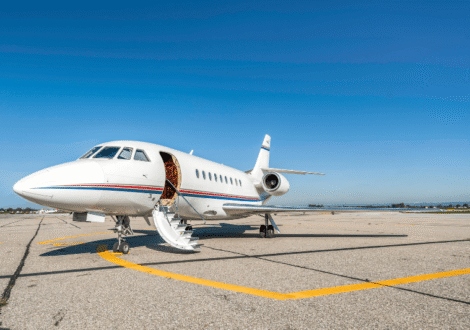 Private jet parked on the apron with cabin door open and stairs deployed