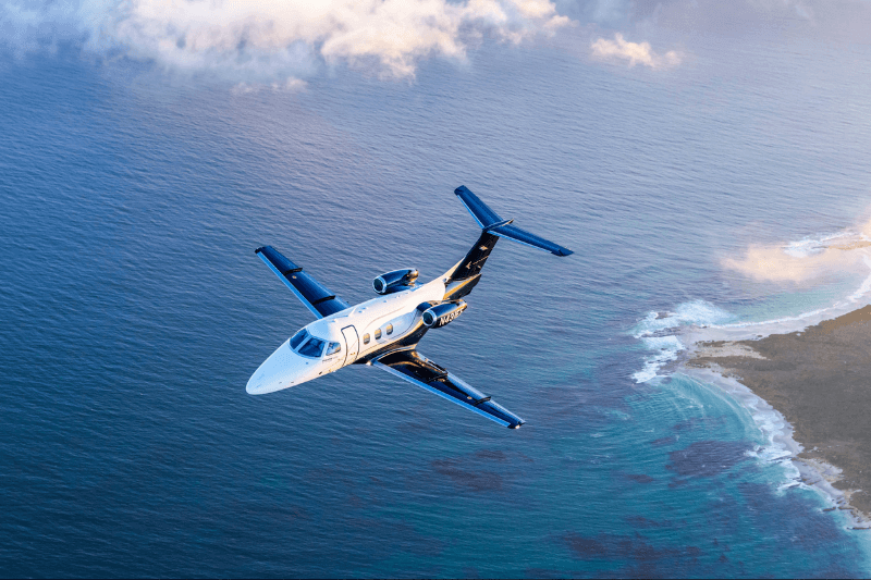 Light private jet flying over open ocean during cruise flight