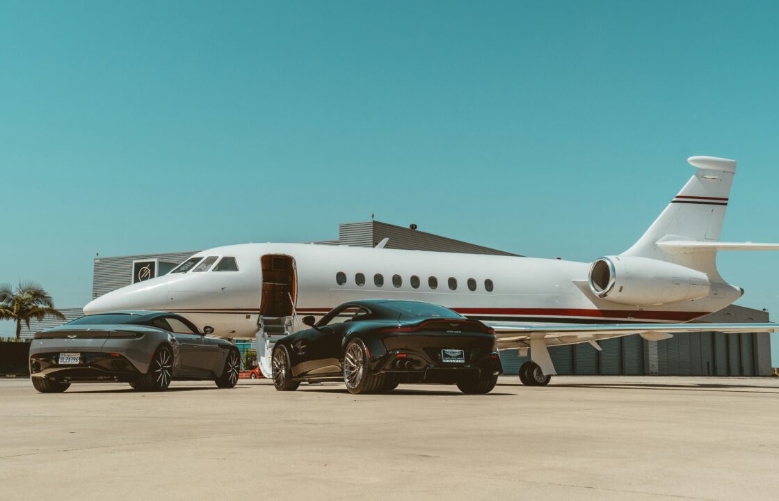 Private jet with luxury cars parked on the airport apron before departure
