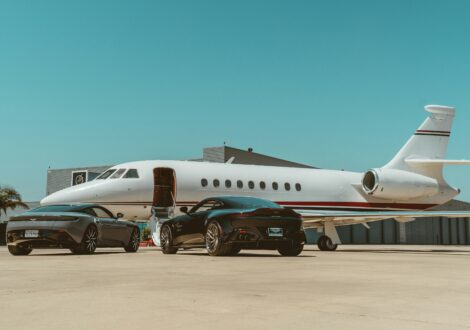Private jet with luxury cars parked on the airport apron before departure