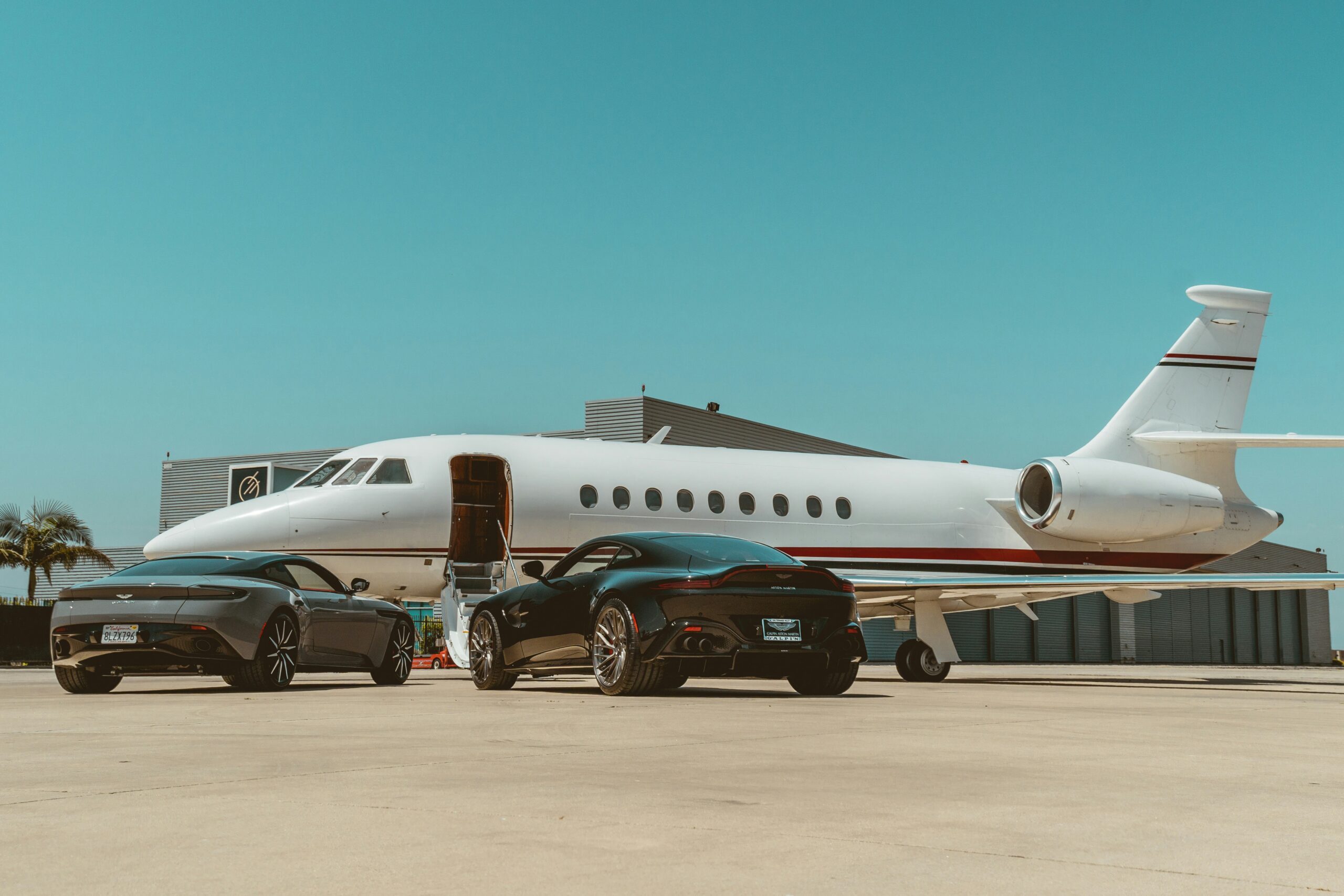 Private jet with luxury cars parked on the airport apron before departure