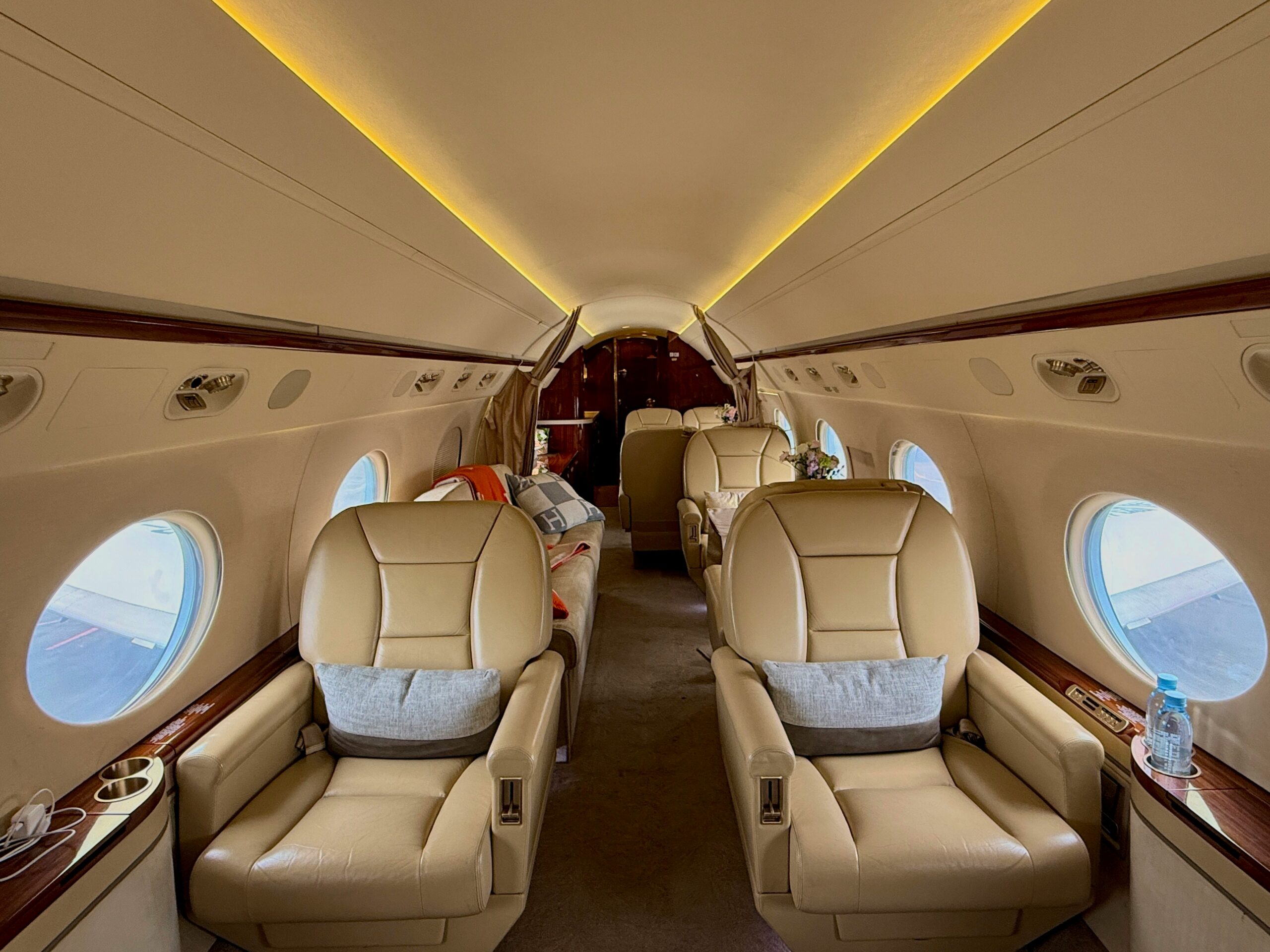 Spacious private jet cabin interior with leather seats and premium lighting
