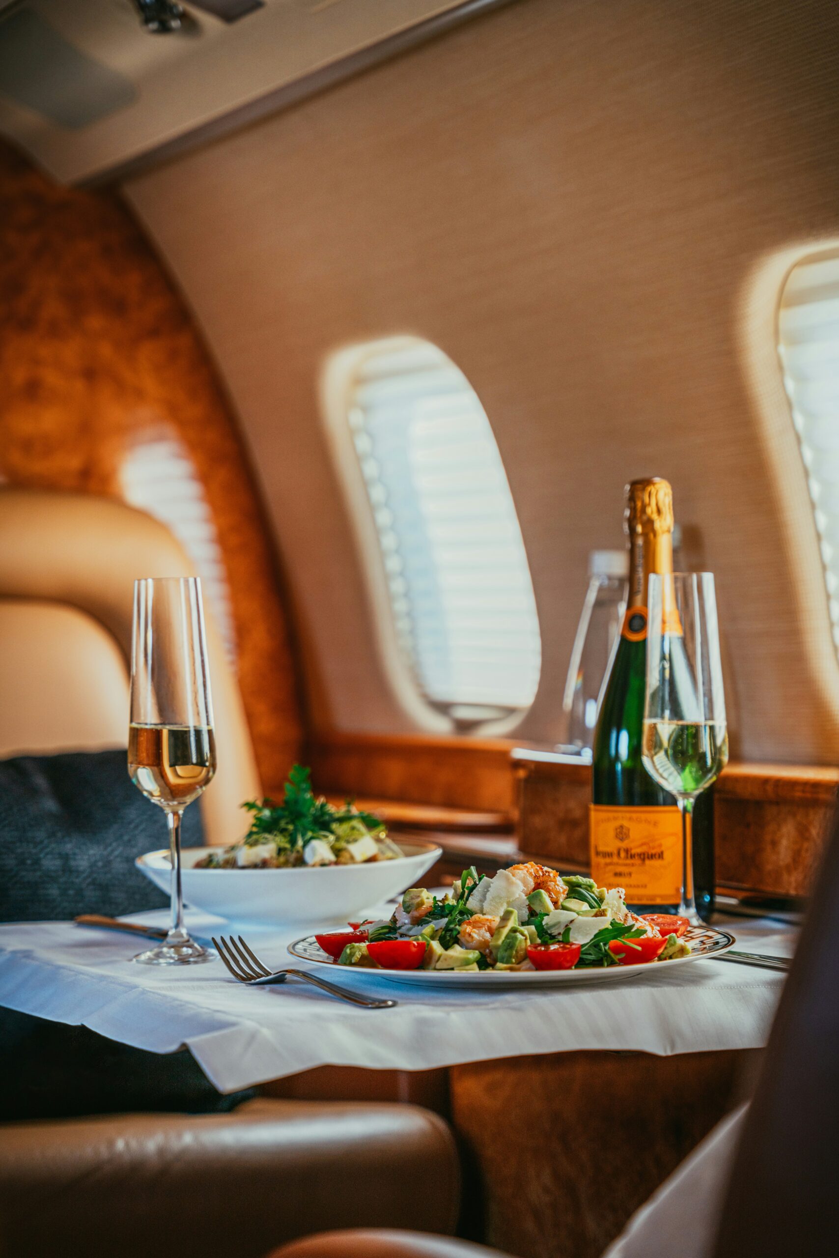 Luxury private jet dining setup with champagne and gourmet meal inside the cabin